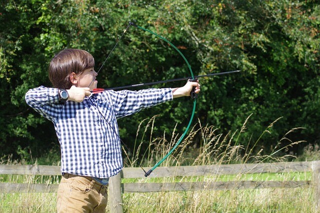 Young boy shooting a bow and arrow